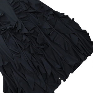 Détail des volants noirs et de la texture plissée en mousseline sur une robe de soirée