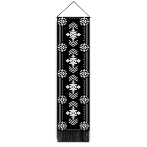 Detail of bohemian tapestry featuring white moon and butterfly patterns with black tassels