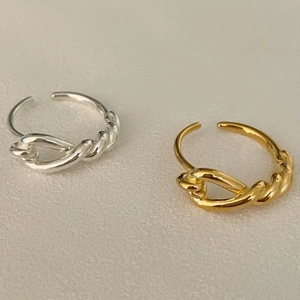 Close-up of minimalist gold and silver knotted rings with an adjustable open design