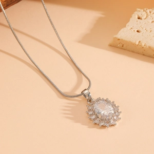 Detail of silver oval pendant with central clear gemstone and pavé zirconia on chain