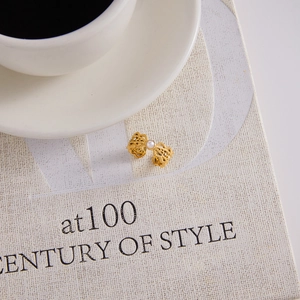 Elegant gold-plated bow ring with a central pearl on a minimalist background