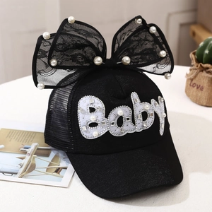 Detail of girls mesh sun hat featuring a large lace bow and pearl baby lettering