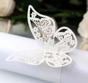 Macro detail of white laser-cut butterfly napkin ring with elegant floral patterns
