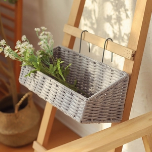 Gray woven cotton rope wall hanging basket with metal hooks and decorative daisies