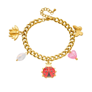 Detail of gold chain bracelet featuring enamel ladybug and crystal heart charms