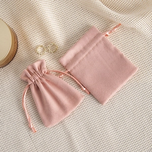 Pink velvet jewelry drawstring bags shown in open and closed states on mesh fabric