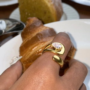 Macro shot of a gold-plated teardrop zircon ring with an adjustable open band design