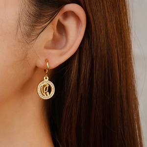 Gold-plated stainless steel hoop earrings with crystal pavé and horse head motif on model
