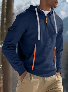 Dettaglio felpa con cappuccio blu navy con zip arancione e tasca utility sulla manica all'aperto