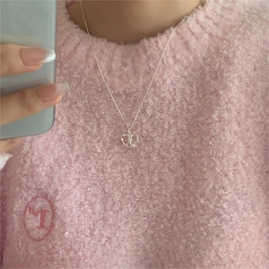 Minimalist 925 sterling silver heart pendant necklace shown on a model with a soft pink sweater