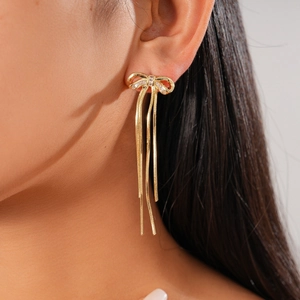 18K gold plated bow earrings with zircon stones and long tassel chains on female model
