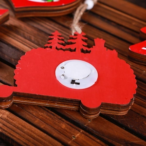 Detail of red wooden Christmas ornament featuring LED battery compartment and switch