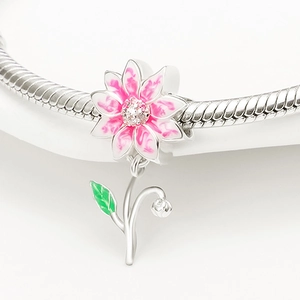 Detalle macro del colgante de girasol de plata con pétalos de esmalte rosa y hoja verde sobre blanco