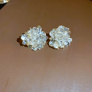 Macro shot of 3D resin flower earrings with shimmering pearlescent petals and rhinestones