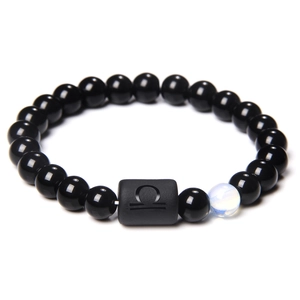 Detail van zwarte kralenarmband met Weegschaal sterrenbeeld op een matte rechthoekige kraal