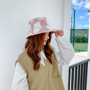 Detail of pink and purple checkered teddy plush bucket hat on model in outdoor natural light