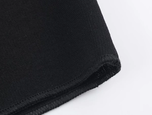 Detailed close-up of premium black knit fabric texture and precision seam stitching