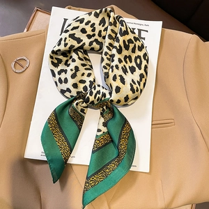 Chic leopard print silk scarf with green stripes on a magazine for women's fashion