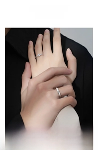 Close-up of S999 sterling silver couple rings worn on hands with brushed textures