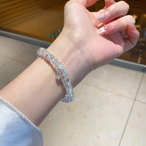 Macro view of faceted clear crystal bracelet featuring a silver crown pendant detail