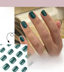 Close-up of short square dark green press-on nails with a glossy polished finish