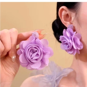Macro shot of large purple fabric flower earrings with detailed multilayered petals