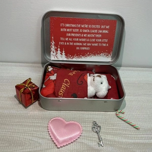 Macro view of Christmas gift set featuring a mini white teddy bear in a silver metal tin box
