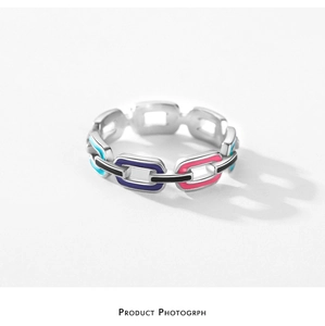 Macro shot of silver link chain ring with colorful enamel inlay in blue and purple