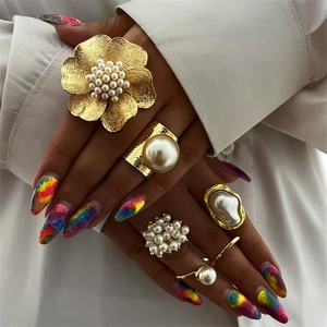 5-piece gold pearl ring set featuring floral and minimalist designs for stylish layering