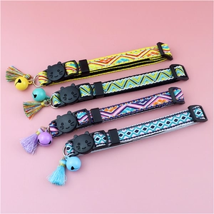 Detail of colorful plaid cat collars with cat-head buckles, bells and tassels
