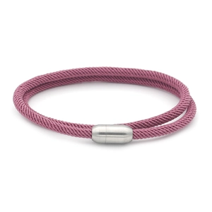 Macro detail of magenta braided rope bracelet with silver cylindrical magnetic closure