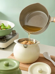 Detail of cream ceramic oil filter pot with stainless steel mesh and pour spout