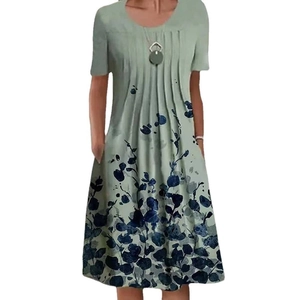 Detail of floral printed dress with pleated crew neck and wooden pendant ornament