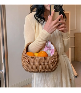 Brown woven basket bag with a pink silk scarf handle detail and fresh citrus fruit