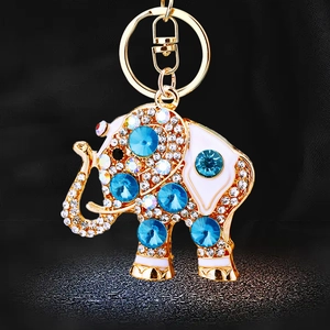 Sparkling crystal elephant keychain in gold metal with blue gems and white enamel detail