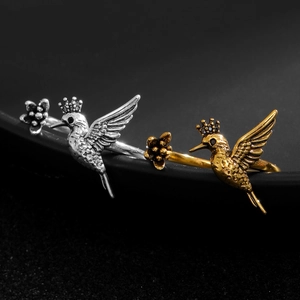 Detailed close-up of vintage hummingbird rings in antique silver and gold finishes.