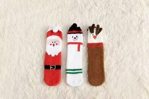 Détail de chaussettes de Noël épaisses en polaire corail avec motifs Père Noël et bonhomme de neige