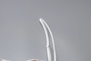 Detail shot of the adjustable white lace dress strap with a metal sliding buckle