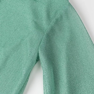 Vue macro du tissu vert menthe avec fil scintillant et détails de couture précis