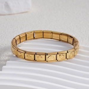 Detail of gold Italian charm bracelet with engraved star, clover, and dolphin icons