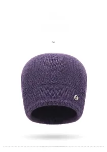 Close-up of deep purple knit beanie showing honeycomb texture and metal M logo
