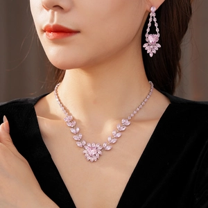 Gros plan d'un mannequin portant un collier cœur en zircon rose et des boucles d'oreilles