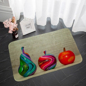 Detail of a rectangular fruit patterned absorbent floor mat on a dark wood floor