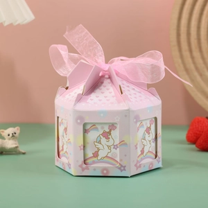 Detailed view of octagonal pink carousel candy box with unicorn motifs and ribbon bow