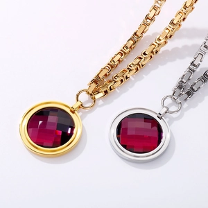 Detailed view of round red glass stone necklace with heavy square link chain in gold and silver