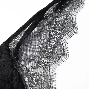 Gros plan exquis de détails de dentelle de cils noire délicate aux motifs floraux