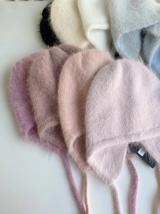 Flache Ansicht von Angora-Kaninchenfell-Wintermützen mit Ohrenklappen in vielen Farben