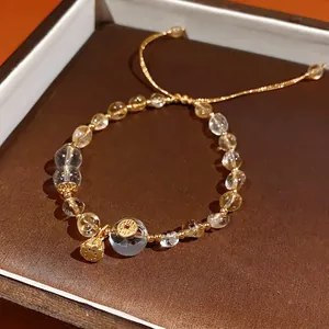 Citrine and clear quartz beaded bracelet with a golden lotus pod charm and pull-string cord