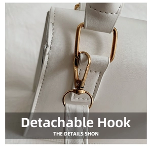 Detail of detachable golden metal hook on white leather crossbody bag strap