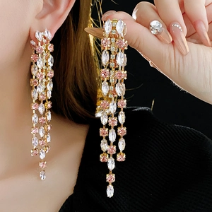 Detail of pink tassel earrings with rhinestones on model and hand display